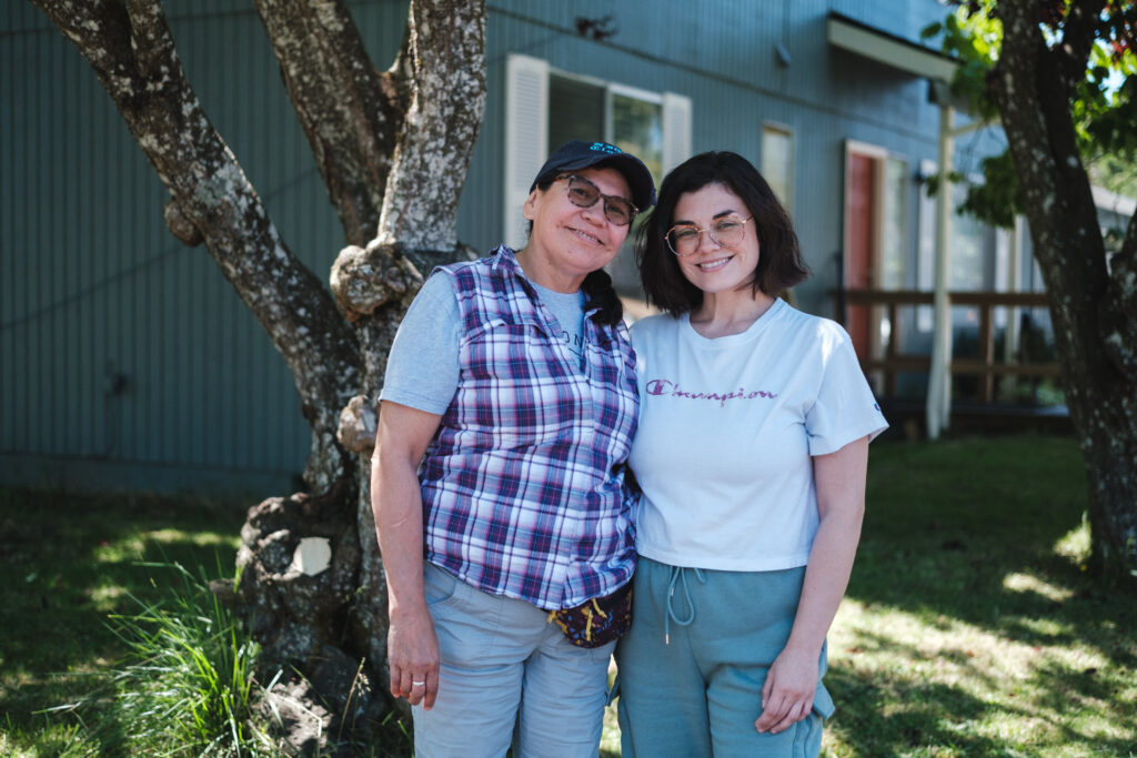 woman standing with her daughter in front of a house